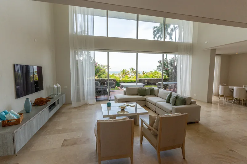 Sala de estar con ventanal panorámico y vista al jardín.